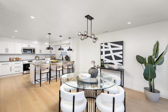 dining room with recessed lighting, visible vents, and light wood-type flooring