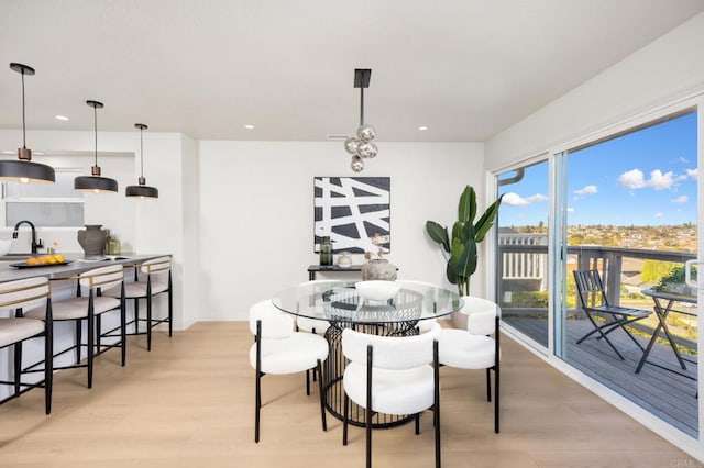 dining space with light wood-type flooring and recessed lighting
