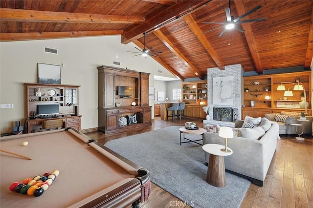 living area with wood ceiling, hardwood / wood-style flooring, ceiling fan, visible vents, and a fireplace