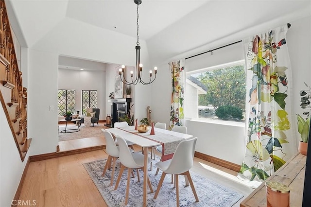 dining room featuring a wealth of natural light, light wood-style floors, a chandelier, and baseboards