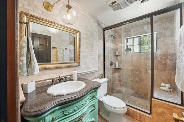 full bath featuring vanity, toilet, a stall shower, and tile walls