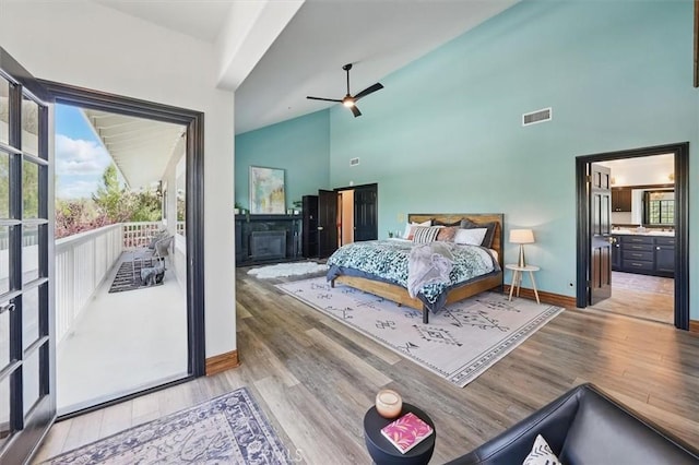 bedroom with high vaulted ceiling, access to outside, visible vents, light wood-style flooring, and baseboards