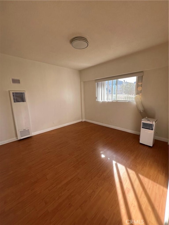 1548 N Alexandria Ave, Los Angeles, CA 90027 - empty room featuring a heating unit, wood finished floors, and baseboards