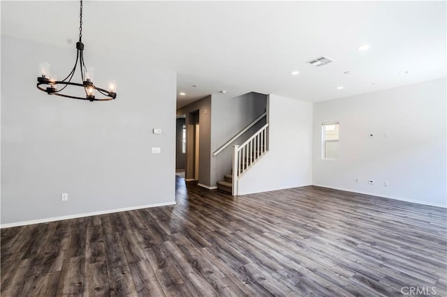 unfurnished living room featuring stairway, visible vents, dark wood-style floors, recessed lighting, and a notable chandelier