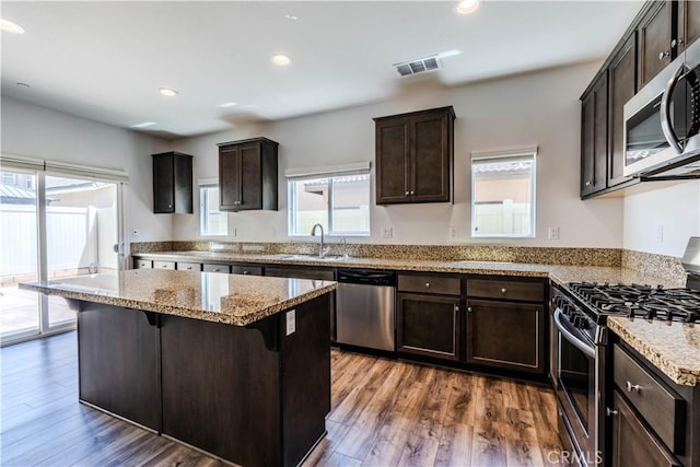kitchen with recessed lighting, appliances with stainless steel finishes, dark brown cabinets, a sink, and visible vents