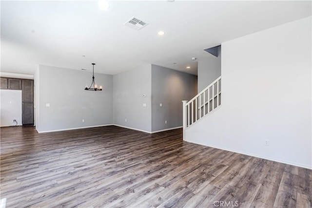 unfurnished living room featuring stairway, visible vents, recessed lighting, wood finished floors, and a notable chandelier
