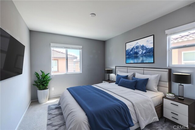 carpeted bedroom featuring multiple windows and baseboards