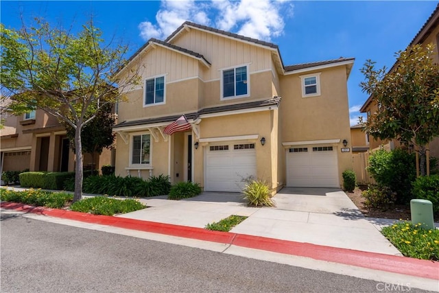 multi unit property with driveway, a garage, stucco siding, and a tiled roof