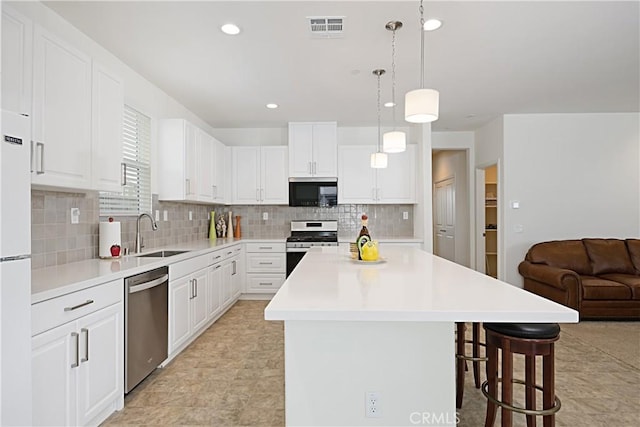 36225 Beacon Light Way, Wildomar, CA 92595 - kitchen featuring a sink, a breakfast bar area, visible vents, a center island, and appliances with stainless steel finishes