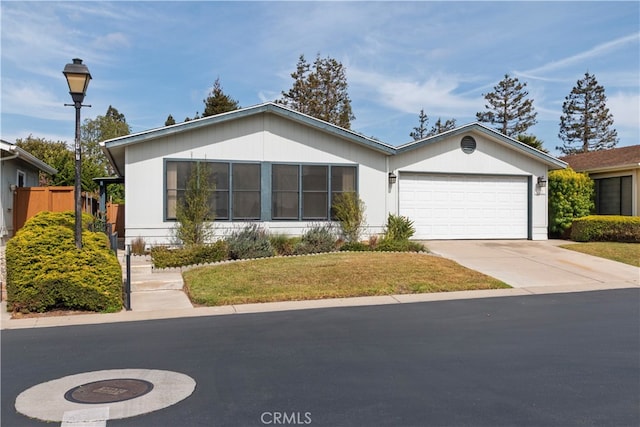 single story home featuring fence, concrete driveway, a front yard, and a garage