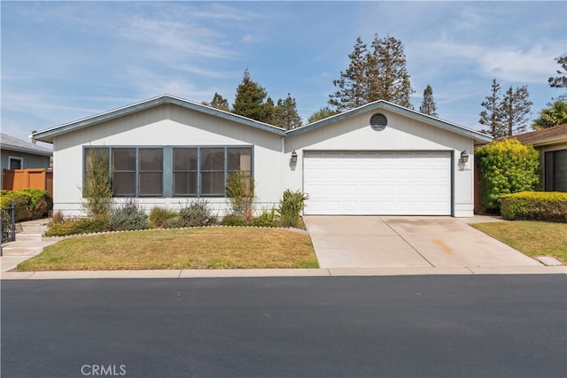 single story home featuring a garage, driveway, and a front yard