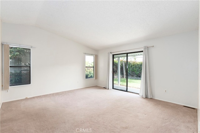 carpeted spare room with vaulted ceiling