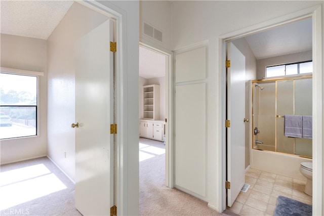 hall with visible vents and light colored carpet