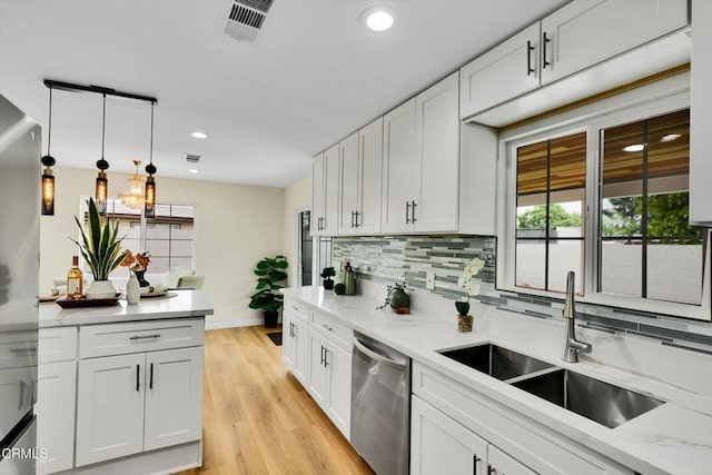 17632 E Covina Blvd, Covina, CA 91722 - kitchen featuring stainless steel dishwasher, backsplash, white cabinetry, light wood-style floors, and hanging light fixtures