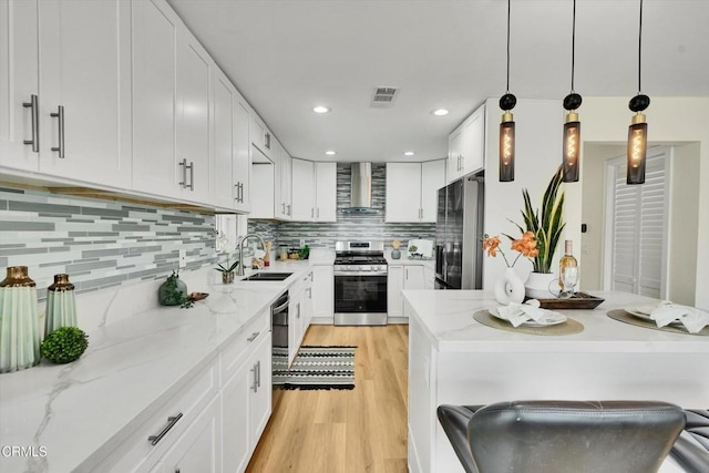 17632 E Covina Blvd, Covina, CA 91722 - kitchen featuring stainless steel appliances, wall chimney range hood, light wood-style floors, white cabinetry, and recessed lighting