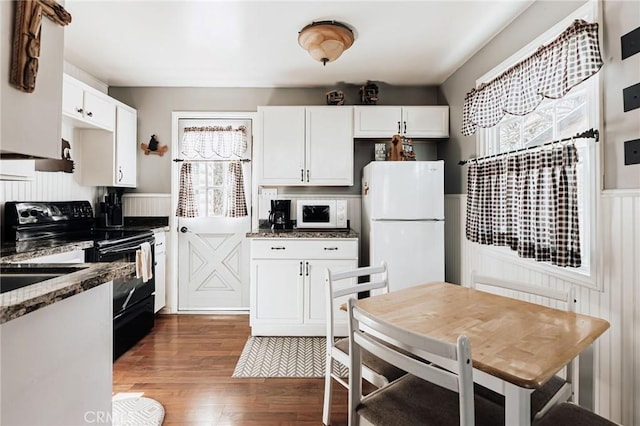 879 Orange Ave, Sugarloaf, CA 92386 - kitchen with white cabinetry, wainscoting, wood finished floors, and white appliances