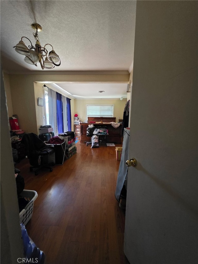 corridor with a chandelier, wood finished floors, and crown molding