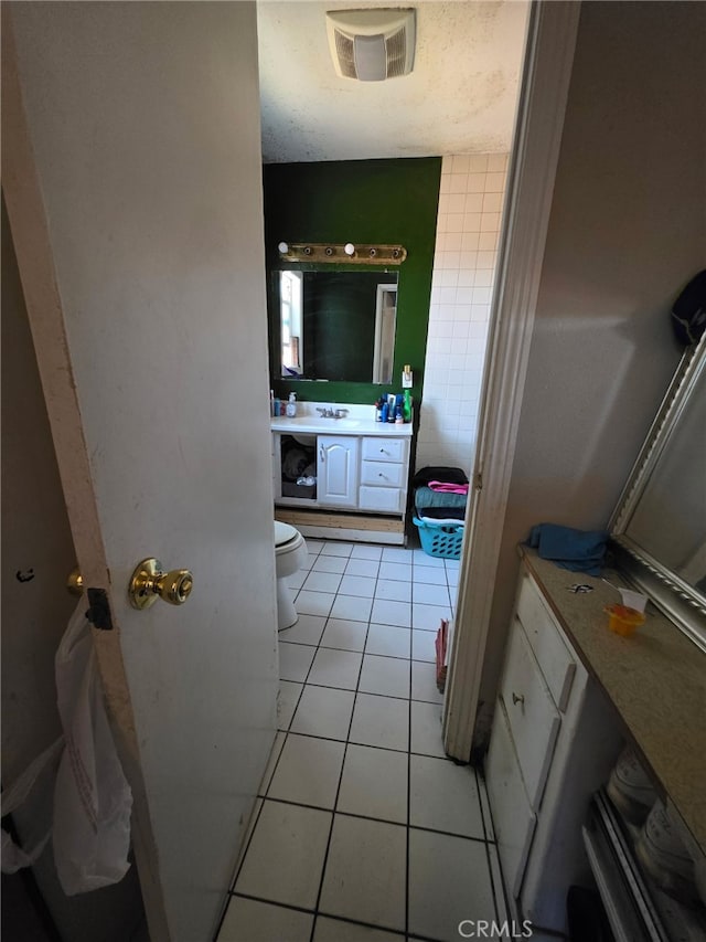 bathroom with visible vents, toilet, tile patterned flooring, and vanity