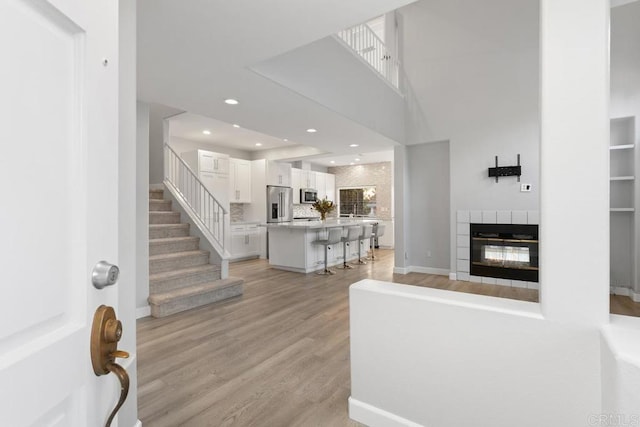 1512 Golfcrest Pl, Vista, CA 92081 - entryway featuring light wood-style flooring, stairs, a tile fireplace, and baseboards