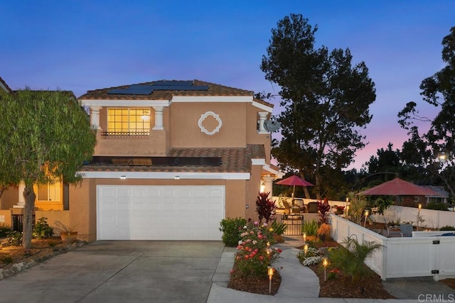 1512 Golfcrest Pl, Vista, CA 92081 - mediterranean / spanish home with driveway, stucco siding, roof mounted solar panels, and an attached garage