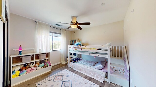 bedroom with baseboards, visible vents, wood finished floors, and ceiling fan