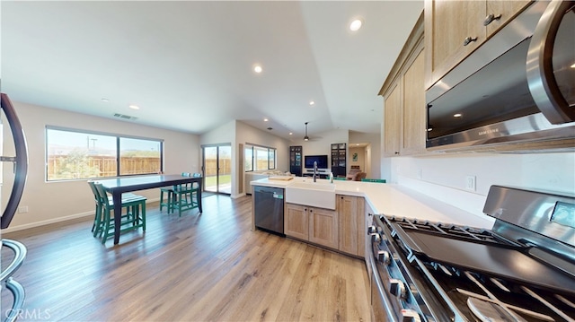 kitchen with light wood-style flooring, a sink, visible vents, stainless steel appliances, and a peninsula