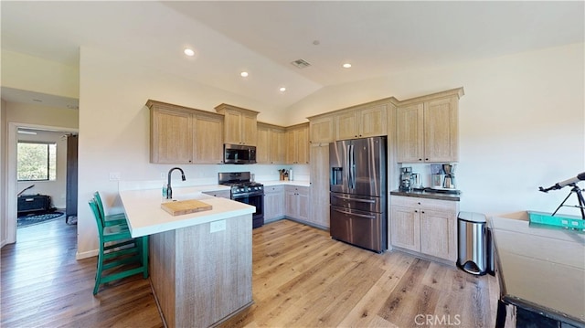kitchen with light wood-type flooring, visible vents, a peninsula, light countertops, and appliances with stainless steel finishes