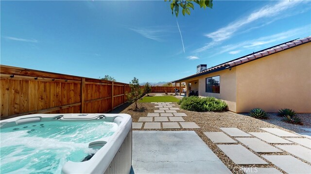 view of yard with a patio, a fenced backyard, and a hot tub
