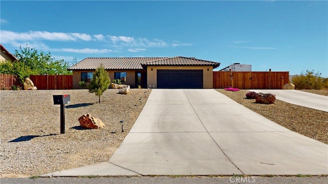 single story home featuring stucco siding, fence, a tile roof, concrete driveway, and an attached garage