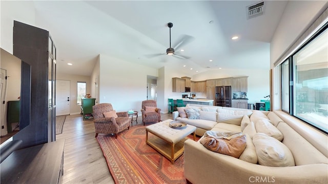 living area featuring recessed lighting, light wood finished floors, ceiling fan, visible vents, and vaulted ceiling