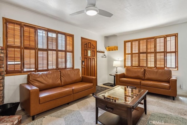 living room with baseboards and ceiling fan