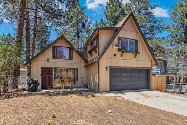 rustic home with fence, concrete driveway, an attached garage, and board and batten siding