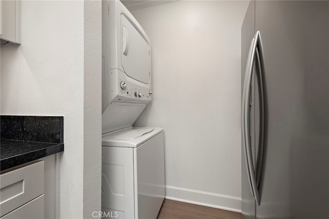 964 Calle Aragon Unit D, Laguna Woods, CA 92637 - washroom featuring stacked washer / dryer, baseboards, and dark wood-style flooring