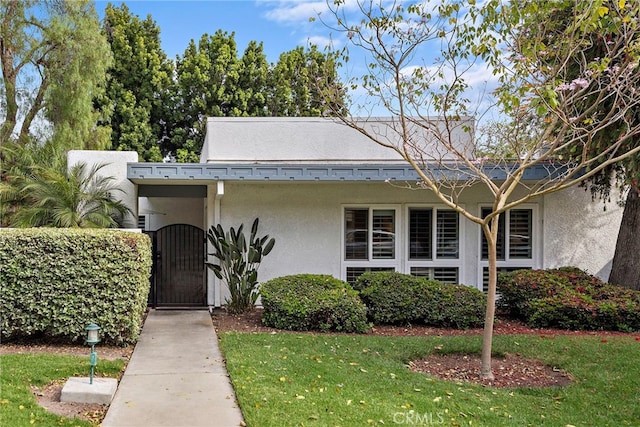 964 Calle Aragon Unit D, Laguna Woods, CA 92637 - bungalow-style home featuring stucco siding, a front lawn, and a gate