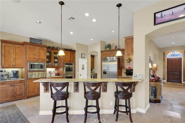 5660 Stoneview Rd, Rancho Cucamonga, CA 91739 - kitchen featuring built in appliances, a warming drawer, brown cabinetry, and arched walkways