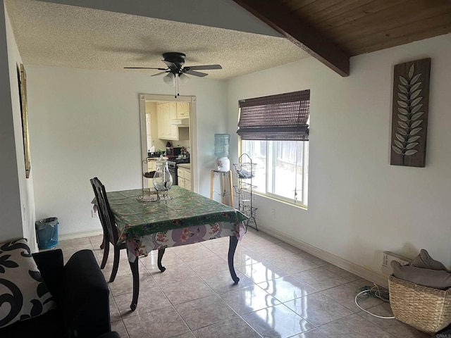 office space with a textured ceiling, baseboards, light tile patterned flooring, and ceiling fan