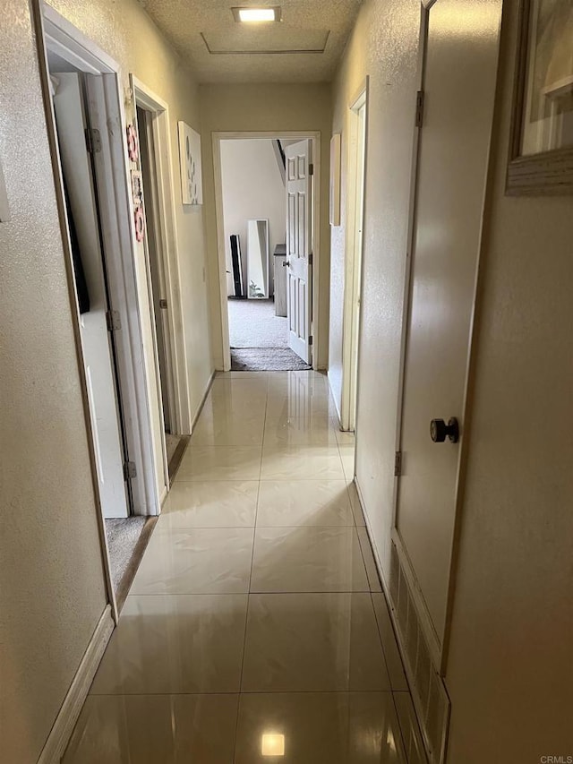 hallway with baseboards and visible vents