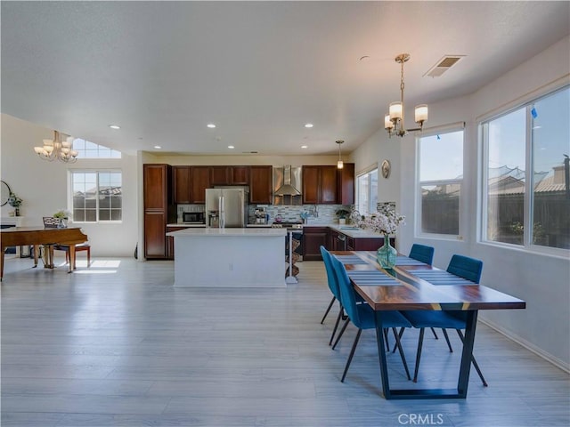 dining space with visible vents, plenty of natural light, and a notable chandelier