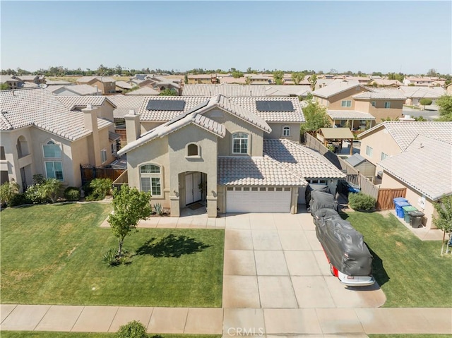 mediterranean / spanish home featuring a residential view, concrete driveway, a tile roof, and fence