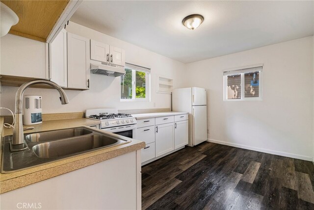 kitchen featuring a sink, white appliances, light countertops, dark wood finished floors, and under cabinet range hood