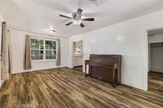 interior space featuring baseboards, a ceiling fan, wood finished floors, and visible vents