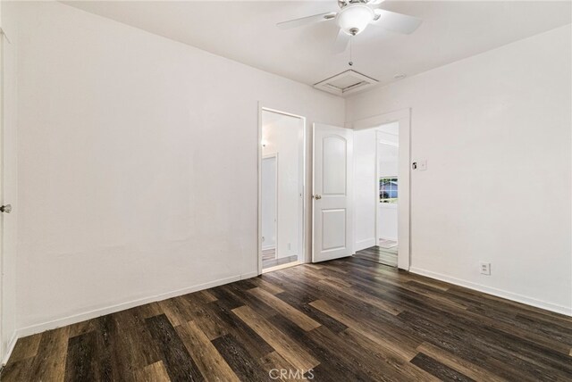 empty room featuring baseboards, a ceiling fan, and dark wood-style floors