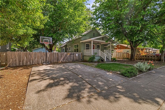view of front of house featuring covered porch and fence private yard
