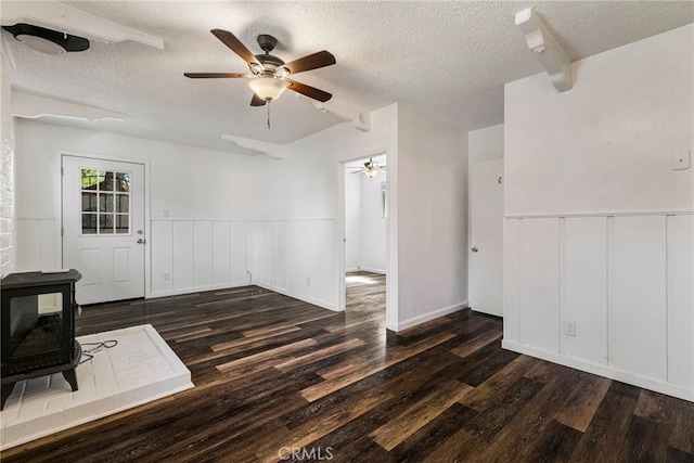 1617 Hemlock St, Chico, CA 95928 - unfurnished living room with a ceiling fan, a textured ceiling, a wood stove, wood finished floors, and wainscoting