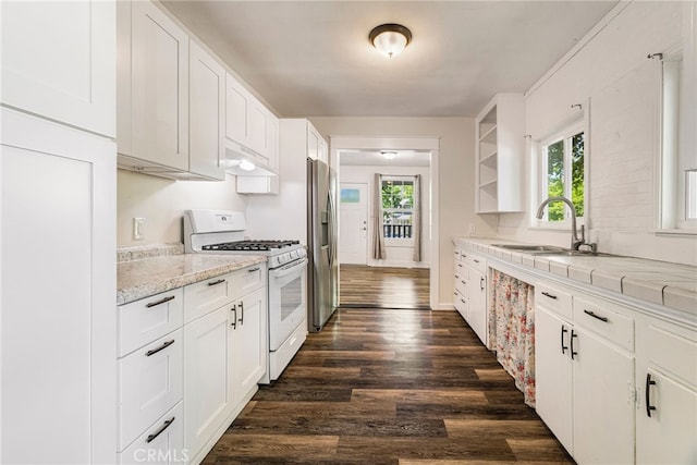 1617 Hemlock St, Chico, CA 95928 - kitchen with white range with gas cooktop, stainless steel fridge, a sink, white cabinets, and dark wood-style floors
