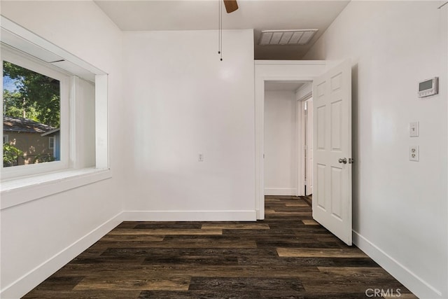 spare room with visible vents, a ceiling fan, baseboards, and dark wood-style flooring