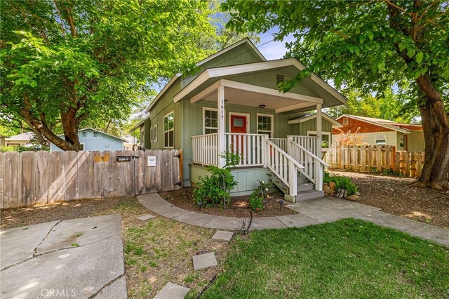 view of front of house with fence, a gate, and covered porch