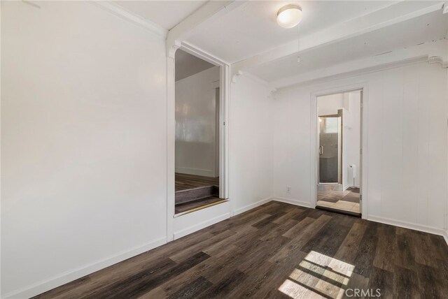 spare room with baseboards and wood finished floors