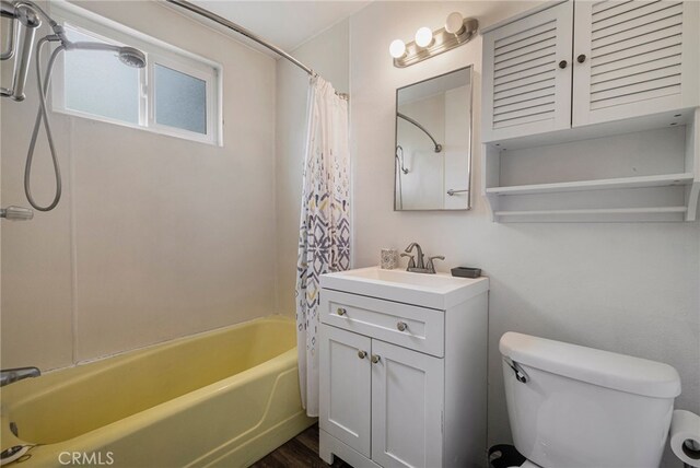 full bath featuring vanity, toilet, wood finished floors, and shower / tub combo