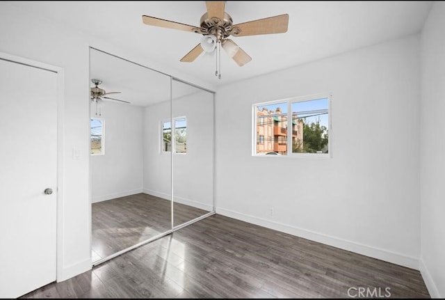unfurnished bedroom with a closet, a ceiling fan, wood finished floors, and baseboards